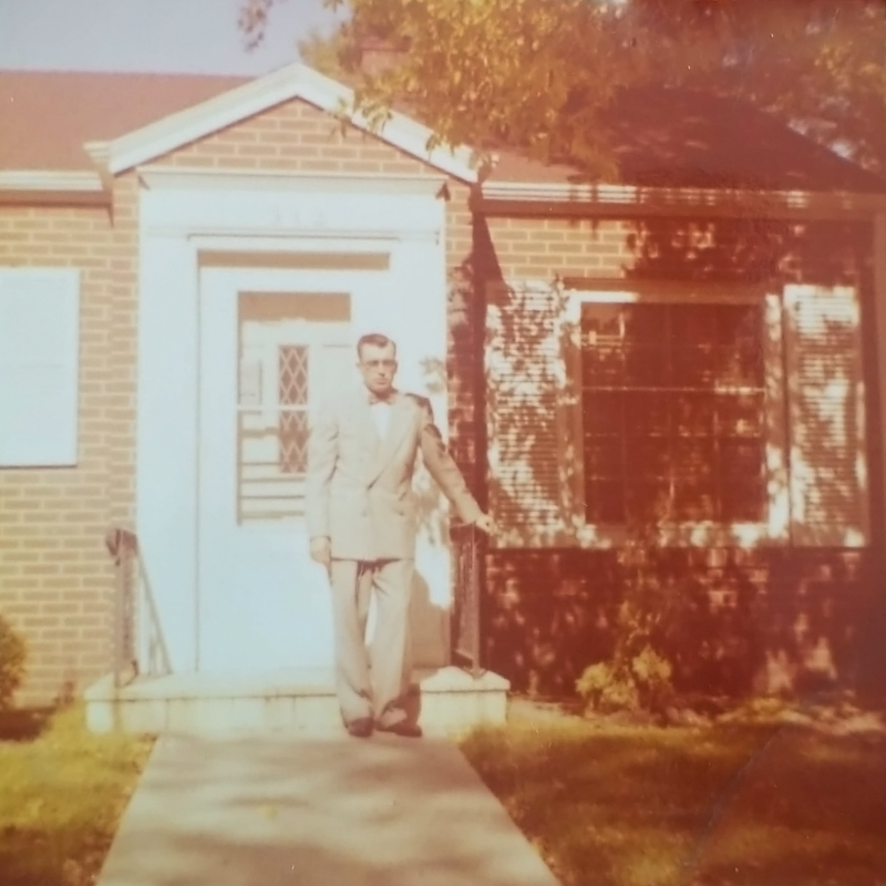 Image description: an old image of Dr. Snyder standing in front of his dental office.